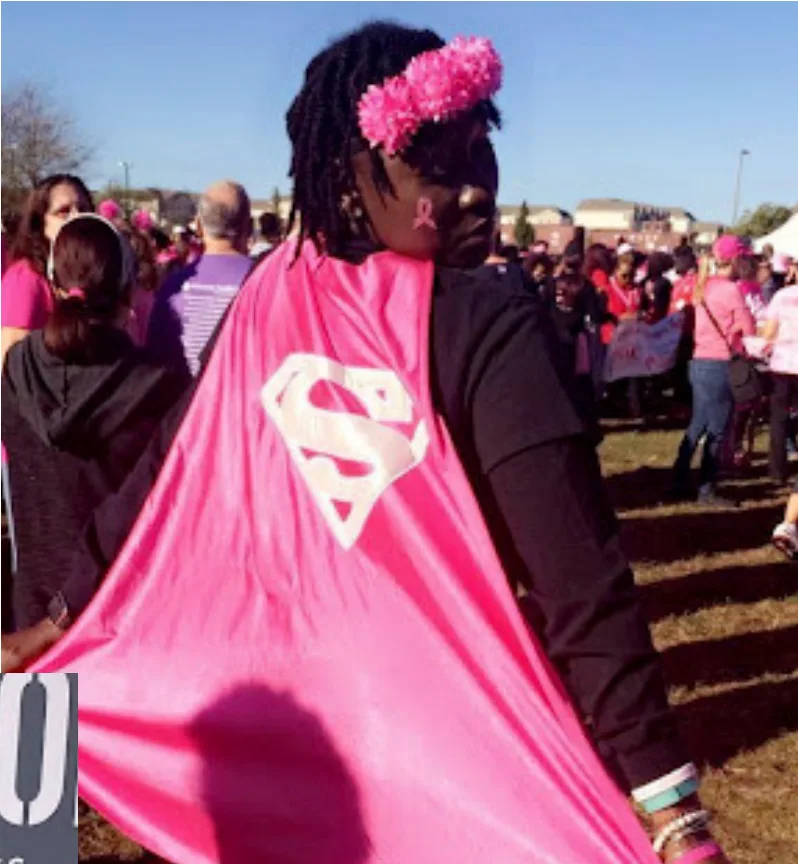 Halimah in a pink superhero cape at a breast cancer walk
